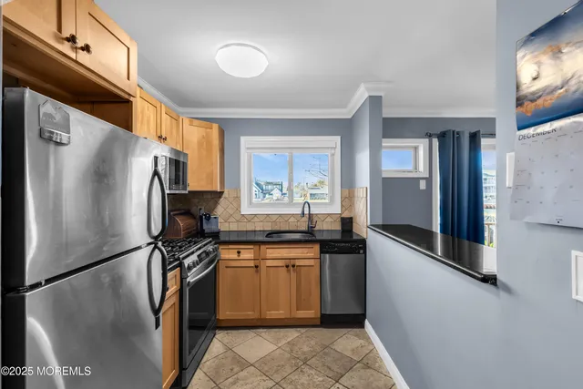 a kitchen with stainless steel appliances granite countertop a refrigerator and a stove