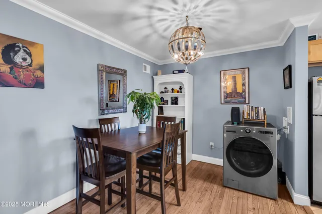 a view of a dining room with furniture a chandelier and wooden floor