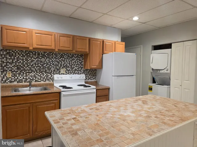 a kitchen with a stove a refrigerator and a sink