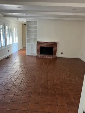 a view of a livingroom with an empty space and a fireplace