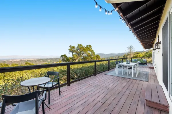 a balcony with wooden floor and outdoor seating