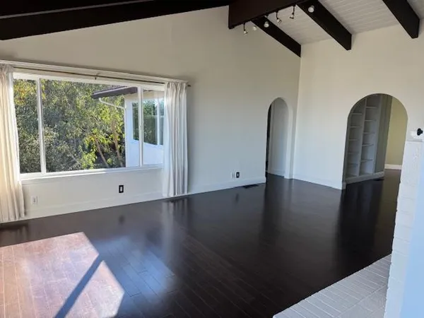 a view of a livingroom with wooden floor and a window