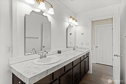 a bathroom with a double vanity sink and a mirror