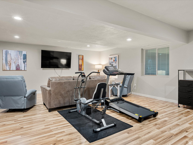 608 Fremont Road Fish Haven, ID 83287 - Photo 26 of 35 Spacious recreational room featuring wood-finish flooring, recessed lighting, a wall-mounted television, and a window with blinds