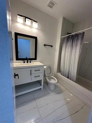 a bathroom with a toilet a sink and mirror