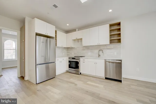 a kitchen with a refrigerator and a stove top oven