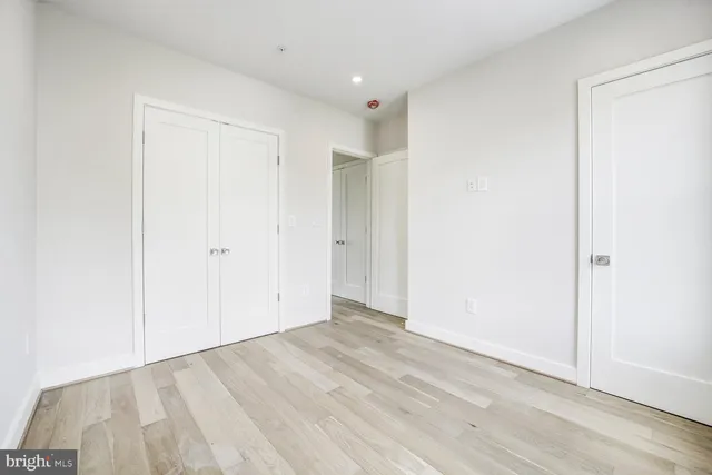 an empty room with wooden floor and closet