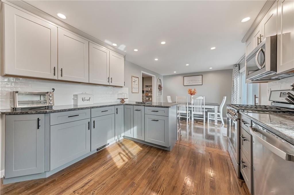 3941 Drexel Road Pittsburgh, PA 15212 - Photo 10 of 25 a kitchen with white cabinets sink and chairs
