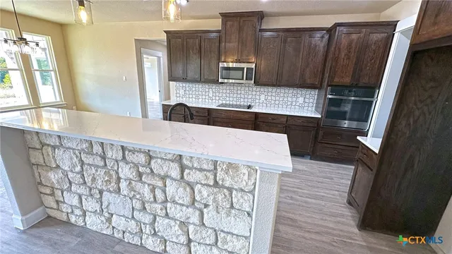 a kitchen with a wooden floor and a refrigerator
