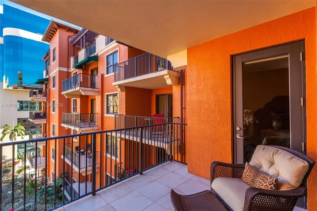 a balcony view with two chairs and a table