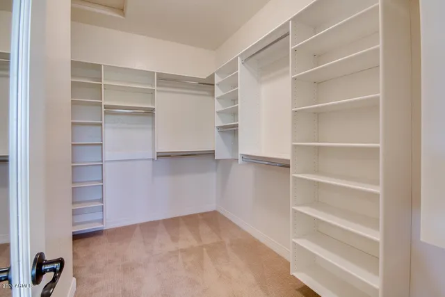 a view of an empty room with window and cabinet
