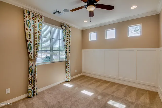 an empty room with a window and a fan