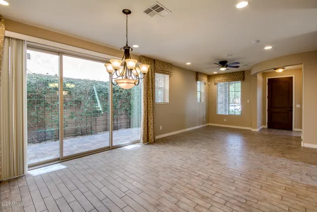 a view of a kitchen with granite countertop stainless steel appliances cabinets a sink and a wooden floor