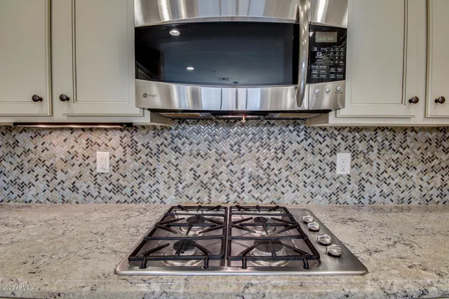 a kitchen with kitchen island granite countertop appliances cabinets and a sink