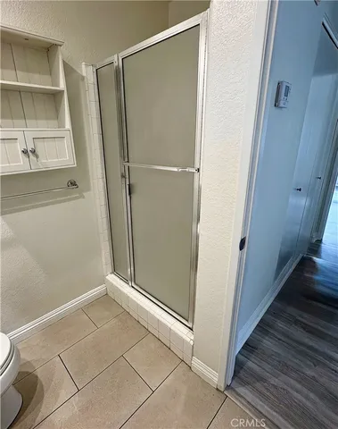 a view of an empty room with wooden floor and a glass door