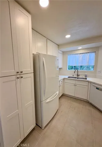 a kitchen with a refrigerator a sink and cabinets