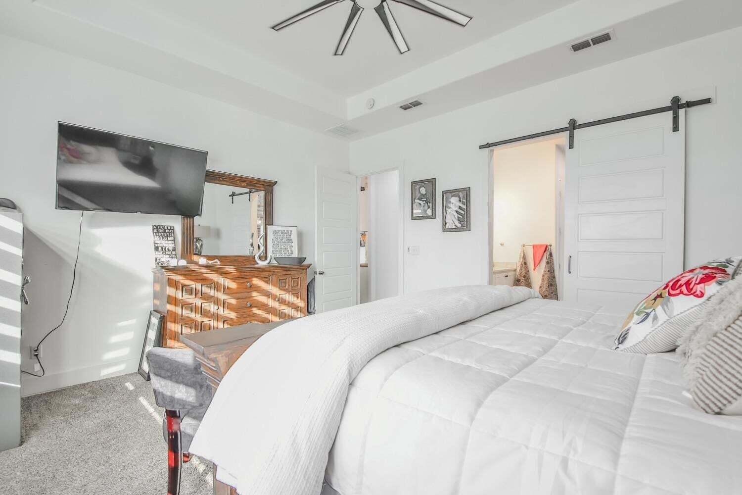 19210 County Road 2240 Lubbock, TX 79423 - Photo 14 of 46 a bedroom with a bed and a chandelier