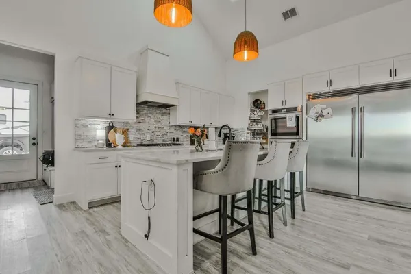 a kitchen with stainless steel appliances granite countertop a white cabinets and stove top oven