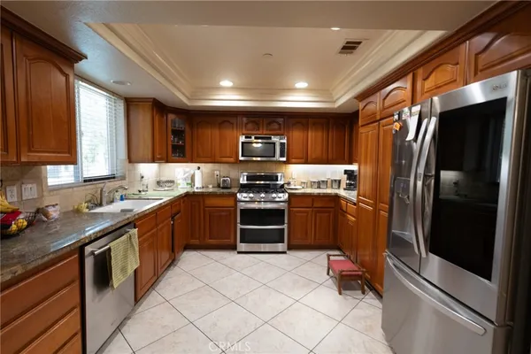 a kitchen with granite countertop stainless steel appliances and wooden cabinets
