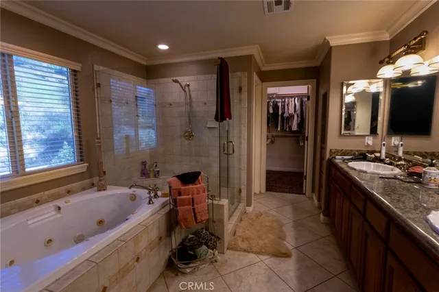a bathroom with a granite countertop tub sink a mirror and a bathtub