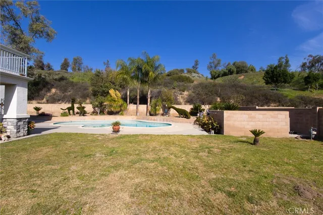 a view of yard with swimming pool and trees
