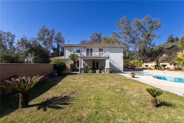 a view of a house with a yard and a fire pit