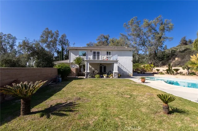 a view of a house with a yard and a fire pit