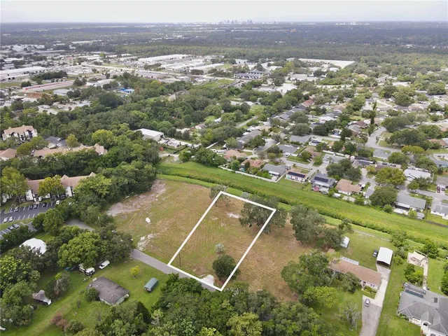 an aerial view of residential houses with outdoor space and trees