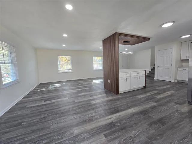 a view of empty room with wooden floor
