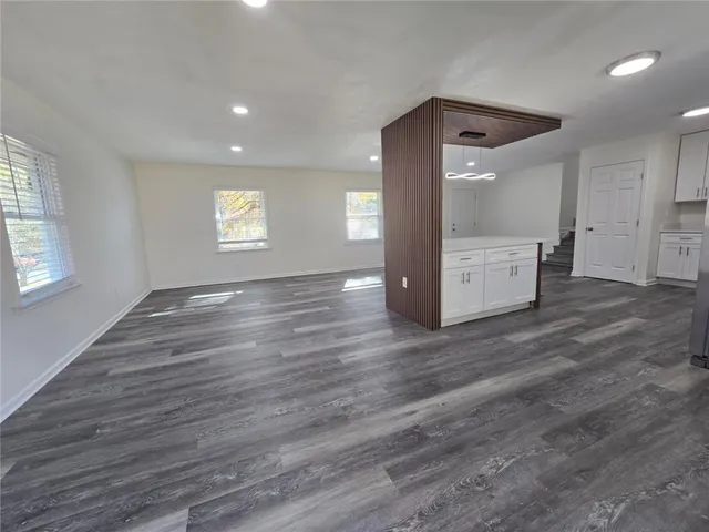 an empty room with wooden floor and a ceiling fan