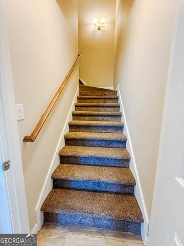 an empty room with a chandelier fan and windows