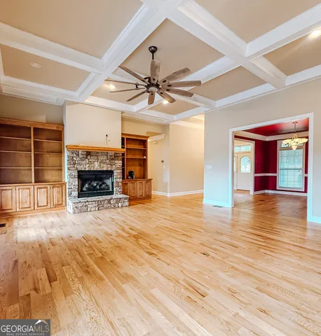 a view of empty room with wooden floor and fireplace