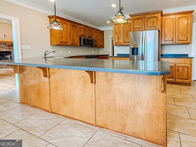 a kitchen with stainless steel appliances granite countertop a refrigerator and microwave