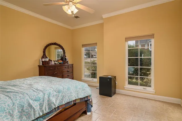 a bedroom with a bed and a dresser next to a window