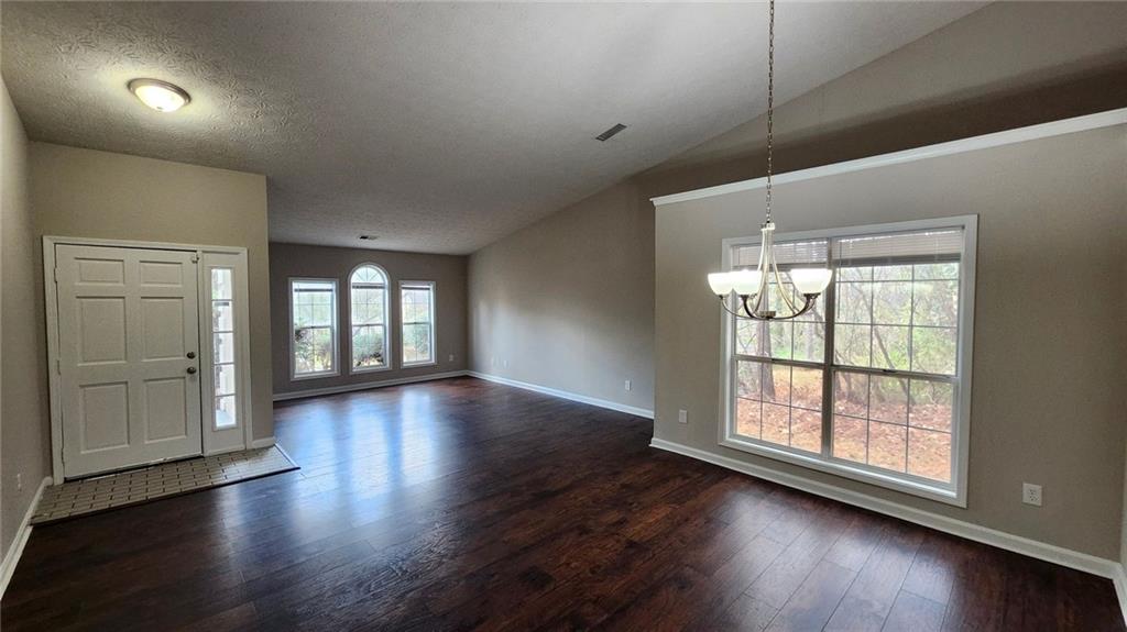 587 North Shore Road Lithonia, GA 30058 - Photo 2 of 16 an empty room with wooden floor and windows