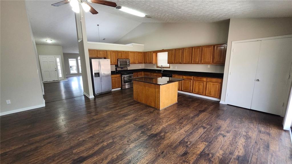 587 North Shore Road Lithonia, GA 30058 - Photo 3 of 16 a kitchen with stainless steel appliances granite countertop a refrigerator a sink dishwasher a stove and white countertops with wooden floor