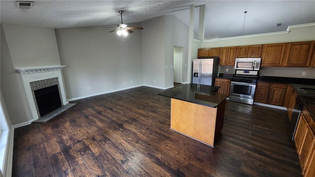 587 North Shore Road Lithonia, GA 30058 - Photo 5 of 16 a kitchen with granite countertop a stove and a microwave