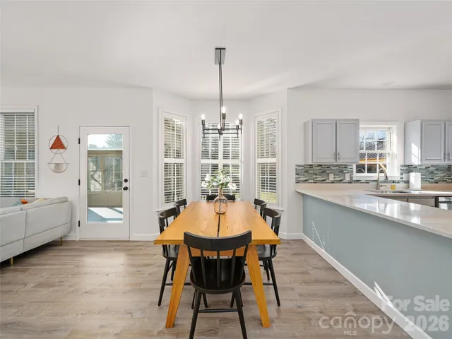 a dining room with furniture a chandelier and wooden floor