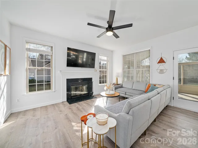 a living room with furniture a flat screen tv and a fireplace