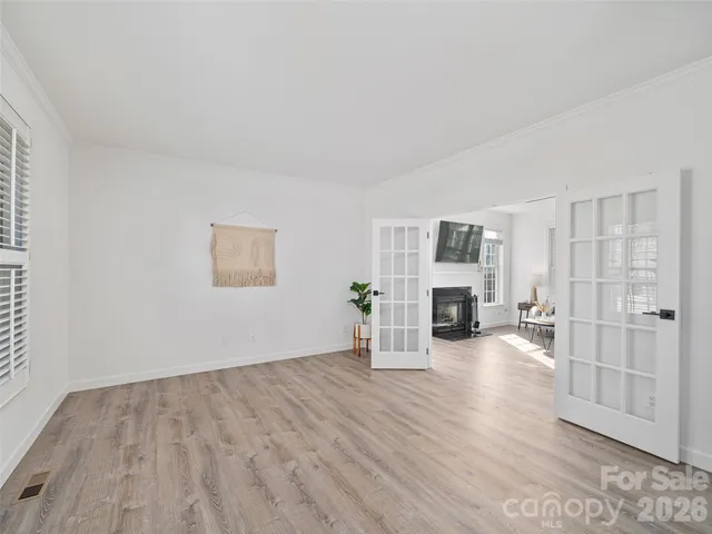 a view of a livingroom with wooden floor fire place and windows