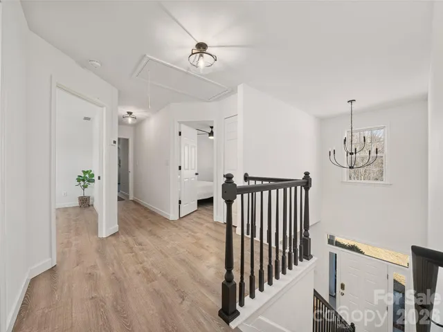 a view of a hallway with wooden floor and staircase
