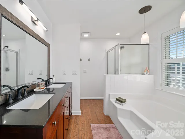 a bathroom with a tub sink and mirror
