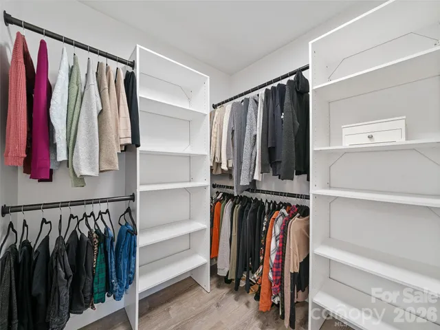 a view of walk in closet with clothes and shoes