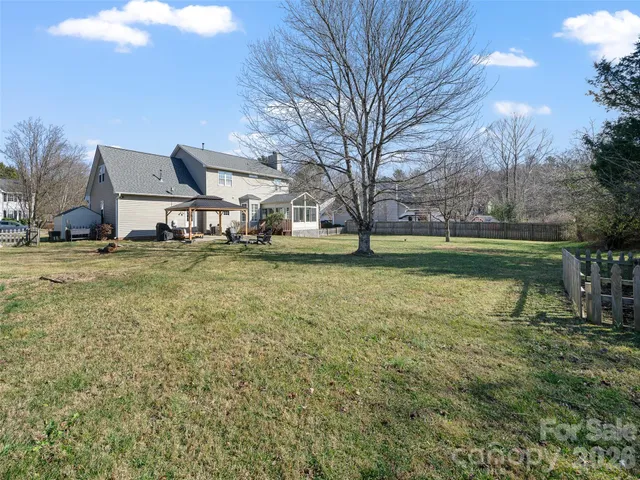 a view of a large pool with lawn chairs under an umbrella