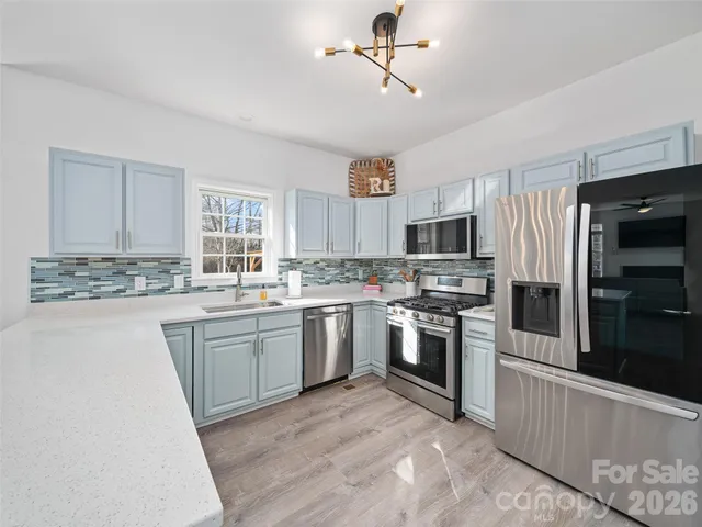 a kitchen with granite countertop a sink stainless steel appliances and cabinets