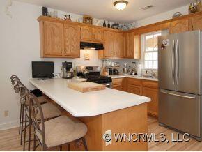 57 Round Top Road Asheville, NC 28803 - Photo 4 of 11 a kitchen with kitchen island a stove a sink and a refrigerator