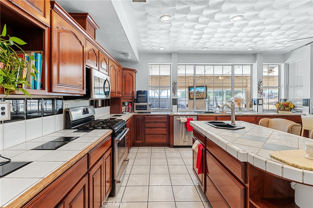 17234 Gamble Avenue Riverside, CA 92504 - Photo 13 of 56 a kitchen with stainless steel appliances granite countertop a sink and a stove