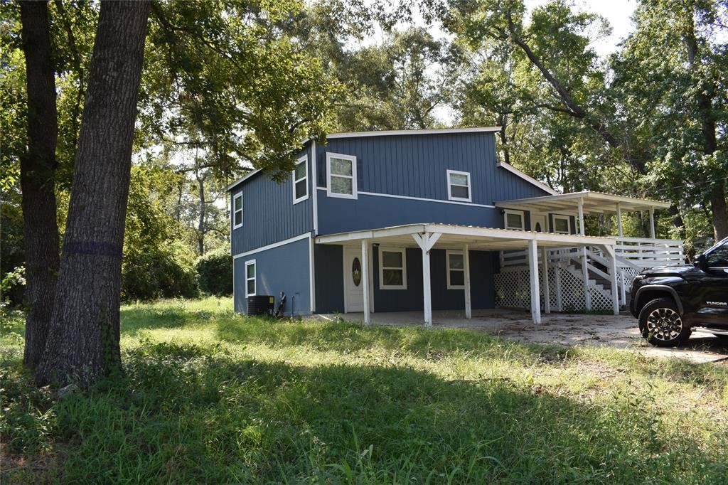 a view of a house with a yard tv and a large tree