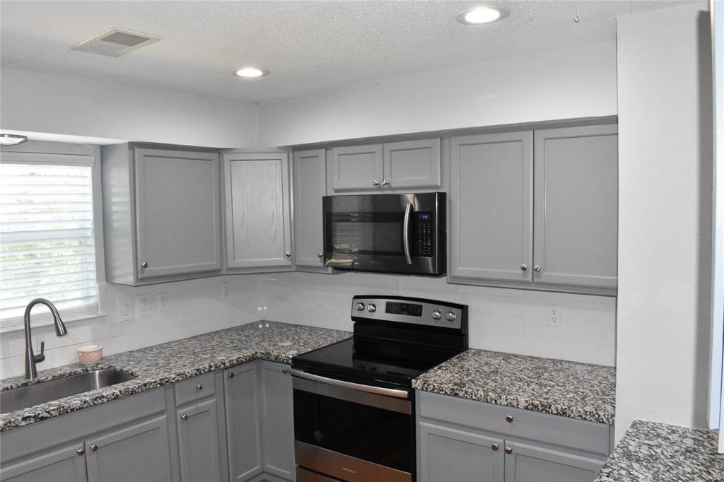 15 Walnut Lane Point Blank, TX 77364 - Photo 16 of 31 a kitchen with granite countertop a sink stainless steel appliances and cabinets
