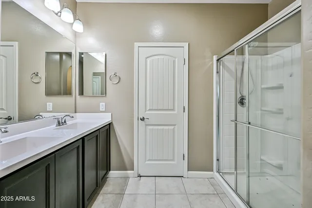 a spacious bathroom with a shower sink and mirror